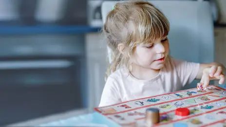 Ein Mädchen spielt ein Brettspiel.