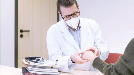Ein Rheumatologe untersucht eine Patientin.