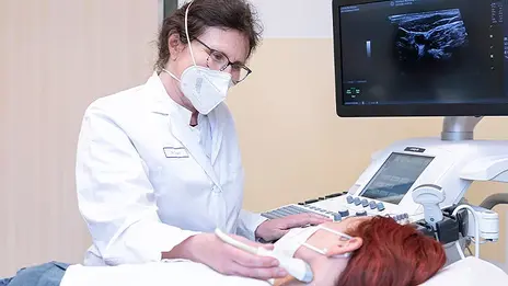 Dr. Gabriele Siegler, Oberärztin, führt bei einer Patientin eine Ultraschalluntersuchung am Hals durch. 