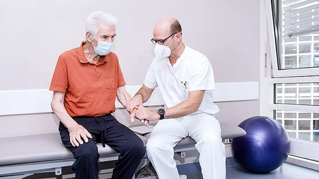 Ein Mitarbeitender unserer Physiotherapie behandelt einen Parkinson-Patienten. 